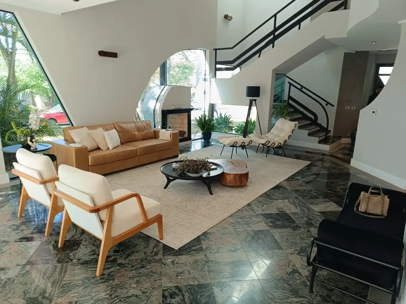Living de pé-direito duplo com sofás e poltronas claros